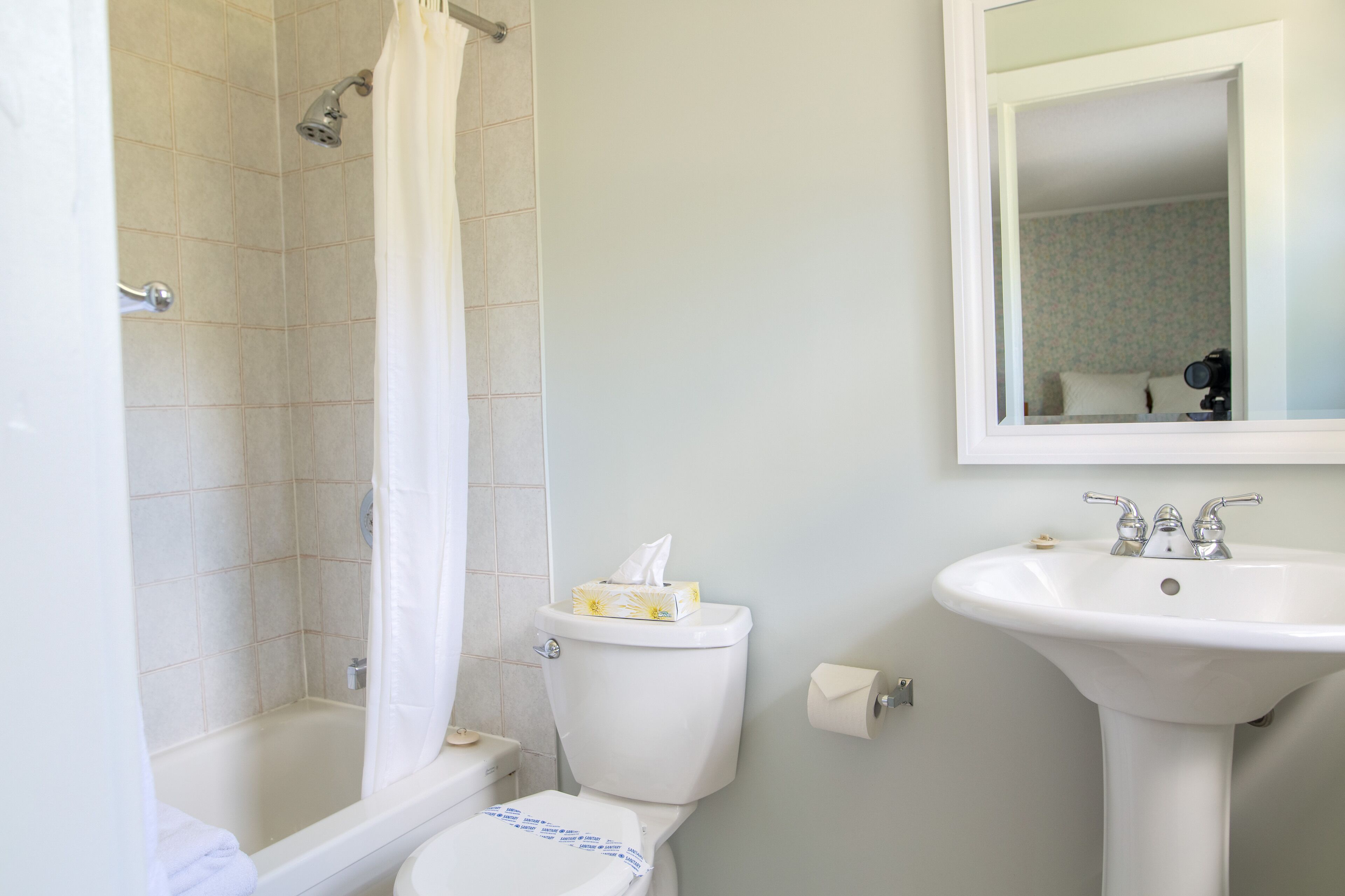 A bathroom with a bathtub, toilet, and sink.