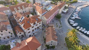 A coastal town with stone buildings, a marina, and a street with pedestrians. - Vila Magdalena (Supetar)