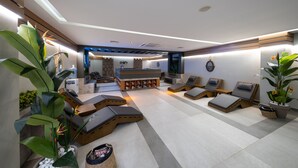 A modern spa area with multiple lounge chairs, a reception desk, and decorative plants. - Anemon Kent Mersin Hotel (Mersin)
