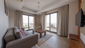 A modern living room with a sofa, coffee table, and a flat-screen TV. - Anemon Kent Mersin Hotel (Mersin)