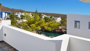 A balcony with a view of a coastal village, white buildings, and a clear blue sky. - Maryianni Apartments (Kithira)