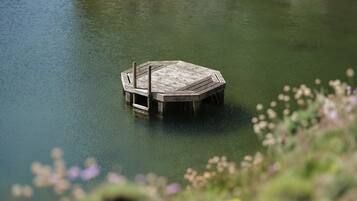 Un muelle de madera que se adentra en una superficie acuática tranquila.