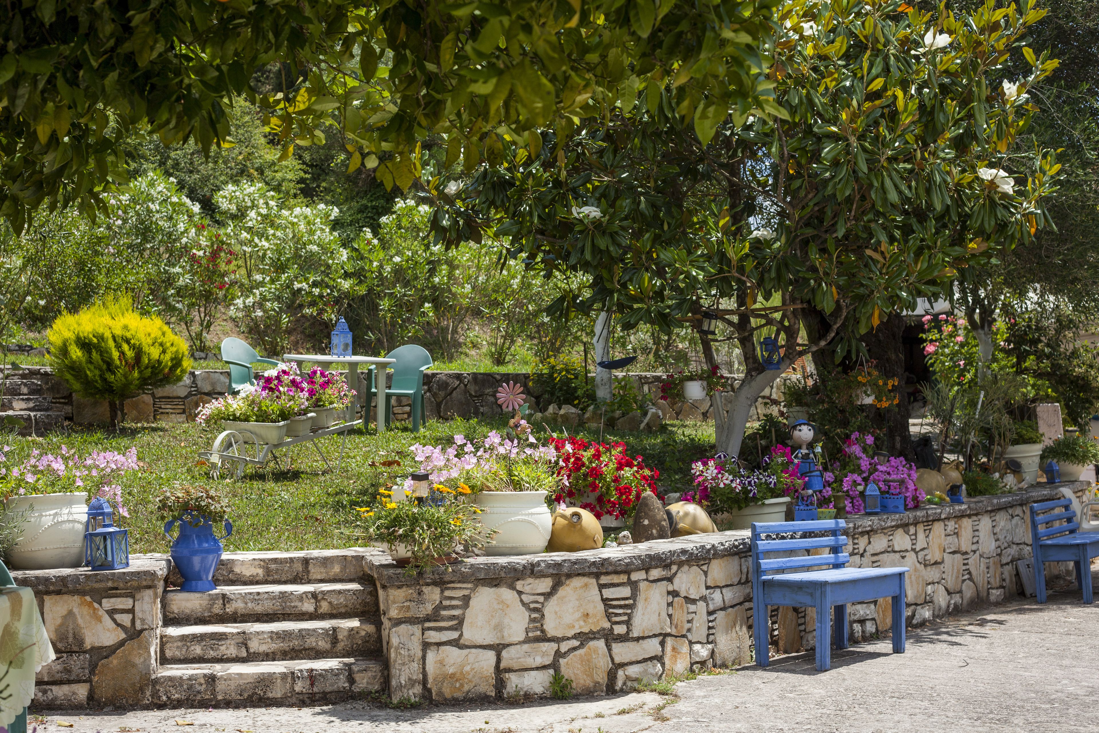 A stone staircase leading to a seating area with blue chairs and potted plants.