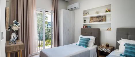 Una camera da letto moderna con due letti, una scrivania e un balcone.