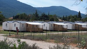 Une rangée de maisons mobiles avec une chaîne de montagnes en arrière-plan.