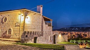 Um edifício de pedra com janelas em arco e uma placa que diz 'Avenza by'.