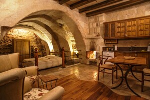 Un interior rústico con un arco de piedra, muebles de madera y una chimenea.