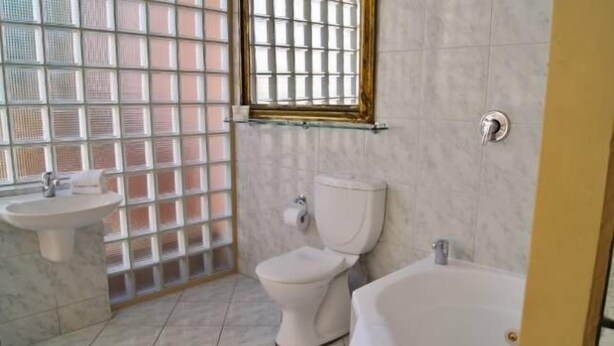 A bathroom with a toilet, sink, and bathtub. - Fire Station Inn - 1 bedroom spa suite (Loggia) (Adelaide North)