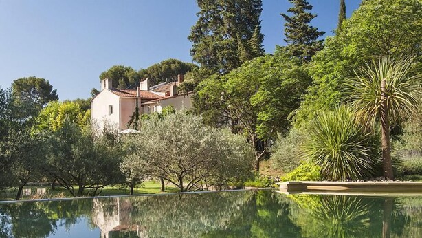 A serene garden with a reflective pond, a small building, and lush greenery. - La Royante (Aubagne)