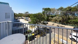 A balcony with a view of a street and parked cars.
