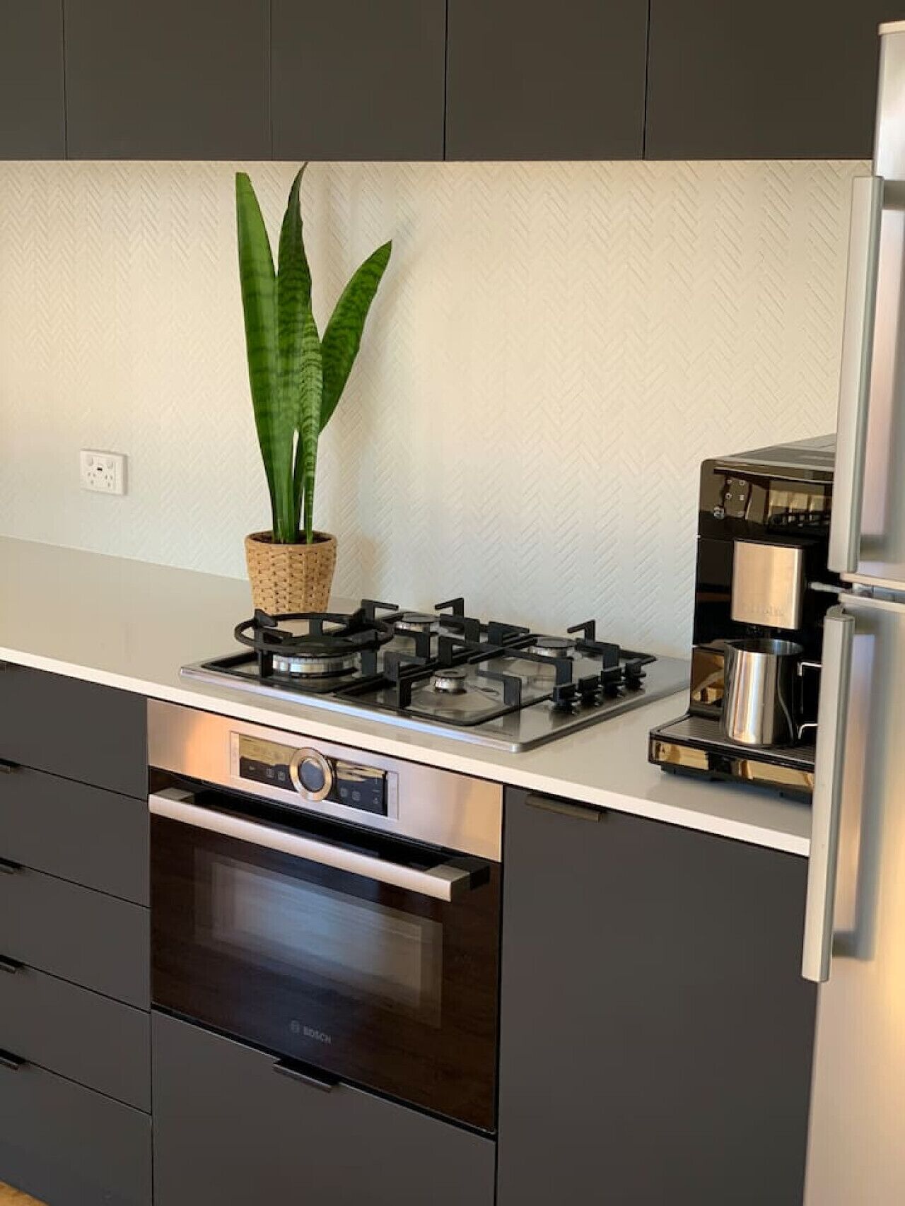 Una cocina con estufa a gas, horno y cafetera.
