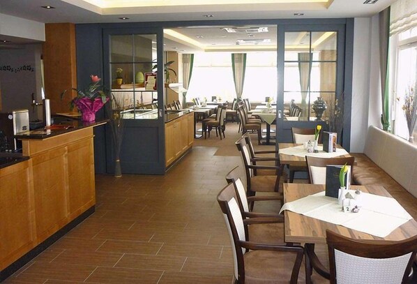 A hotel lobby with a reception desk, seating area, and large windows.