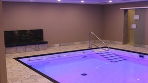 A swimming pool with a stone border and a metal ladder. - Hotel Muschinsky (Bad Lauterberg)
