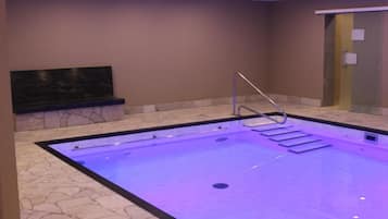 Una piscina techada, sillones reclinables de piscina