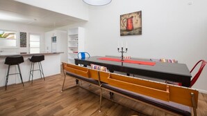 A modern kitchen with white cabinets, a wooden countertop, and a bar area with stools. - The Abbey - Gorgeous Living In the Village (Point Wells)
