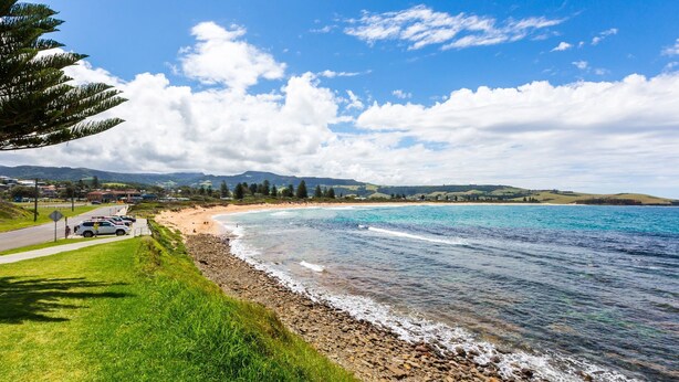 A coastal road with a beach, clear skies, and distant hills. - Home away from home - Close to the beach (GERRINGONG)