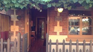 A brick building with a wooden fence and a sign that reads "WILMINGTON FIRST." - Melbourne Street Mews Spa Cottage (Adelaide City)