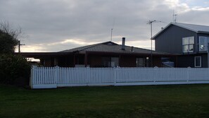 A house with a white picket fence, a garage, and a large window. - Port Albert Holiday House, great for families, with an awesome water view.  (Port Albert)