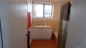 A small bathroom with a white sink, a window, and a shower. - Port Albert Holiday House, great for families, with an awesome water view.  (Port Albert)