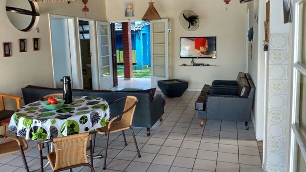 A spacious living area with a dining table, chairs, a sofa, and a TV. - House in Boracéia II with Pool, 3 Bedrooms (2 Suites), Billiard Table, 4 Bathrooms (São Sebastião)