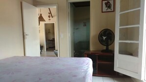 A bedroom with a bed, a wardrobe, a fan, and a door leading to another room. - House in Boracéia II with Pool, 3 Bedrooms (2 Suites), Billiard Table, 4 Bathrooms (São Sebastião)