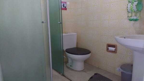 Ein kleines Badezimmer mit Toilette, Waschbecken und Mülleimer.