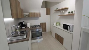 A compact kitchen with a sink, stove, oven, and microwave. - Bed and breakfast Ledwars (Taviano)