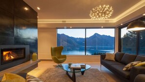 A modern living room with a fireplace, a glass coffee table, and a sofa.