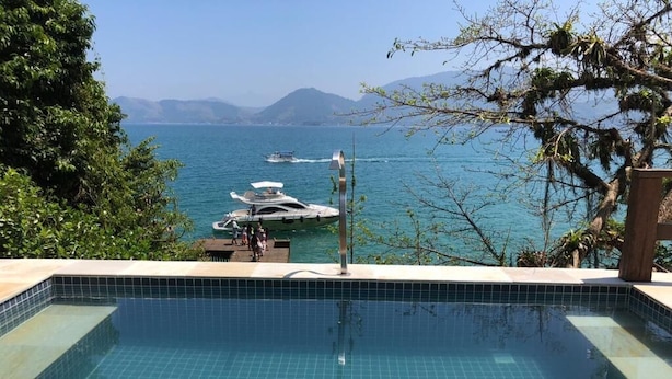 Une piscine avec vue sur la mer et les bateaux.