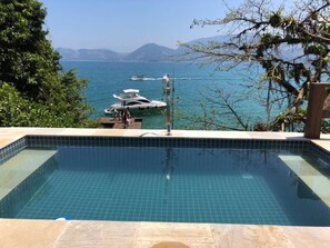 Una piscina con vistas al mar y barcos.