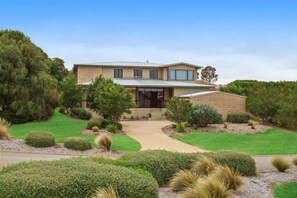 A modern two-story house with a well-maintained lawn and various shrubs. - Convenient For Families, Golfers and Hot Spring Enthusiasts (Fingal)