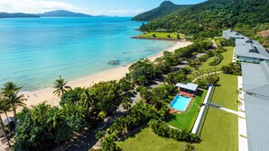 An aerial view of a resort with a beach, swimming pool, and lush greenery. - Lagoon 006 Hamilton Island by HamoRent (Hamilton Island)