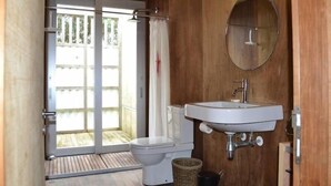 A bathroom with a toilet, sink, and a mirror.