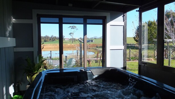 Un jacuzzi con vistas a un estanque y el paisaje circundante.