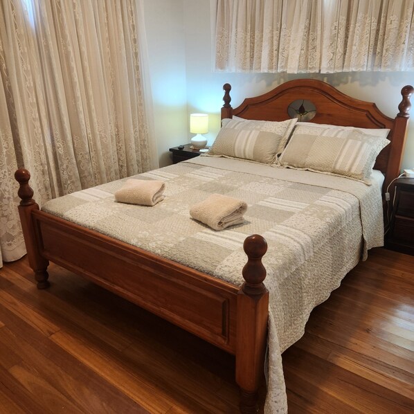 A wooden four-poster bed with a quilted bedspread and two folded towels. - Kyvale Cottage - Country retreat (The Pocket)