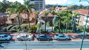 Stroll through a charming suburban neighborhood with single-family homes surrounded by lush greenery and palm trees.