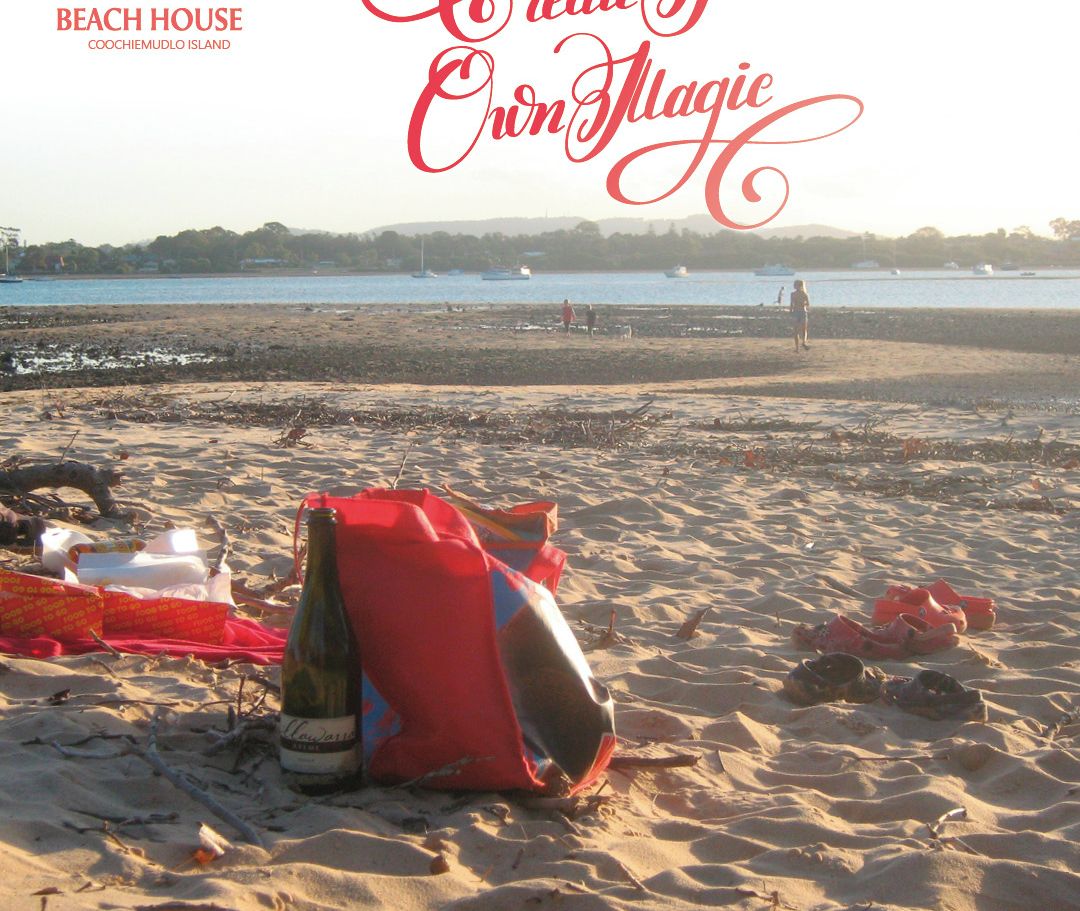 A beach with a tent, a bottle, and a bag on the sand.