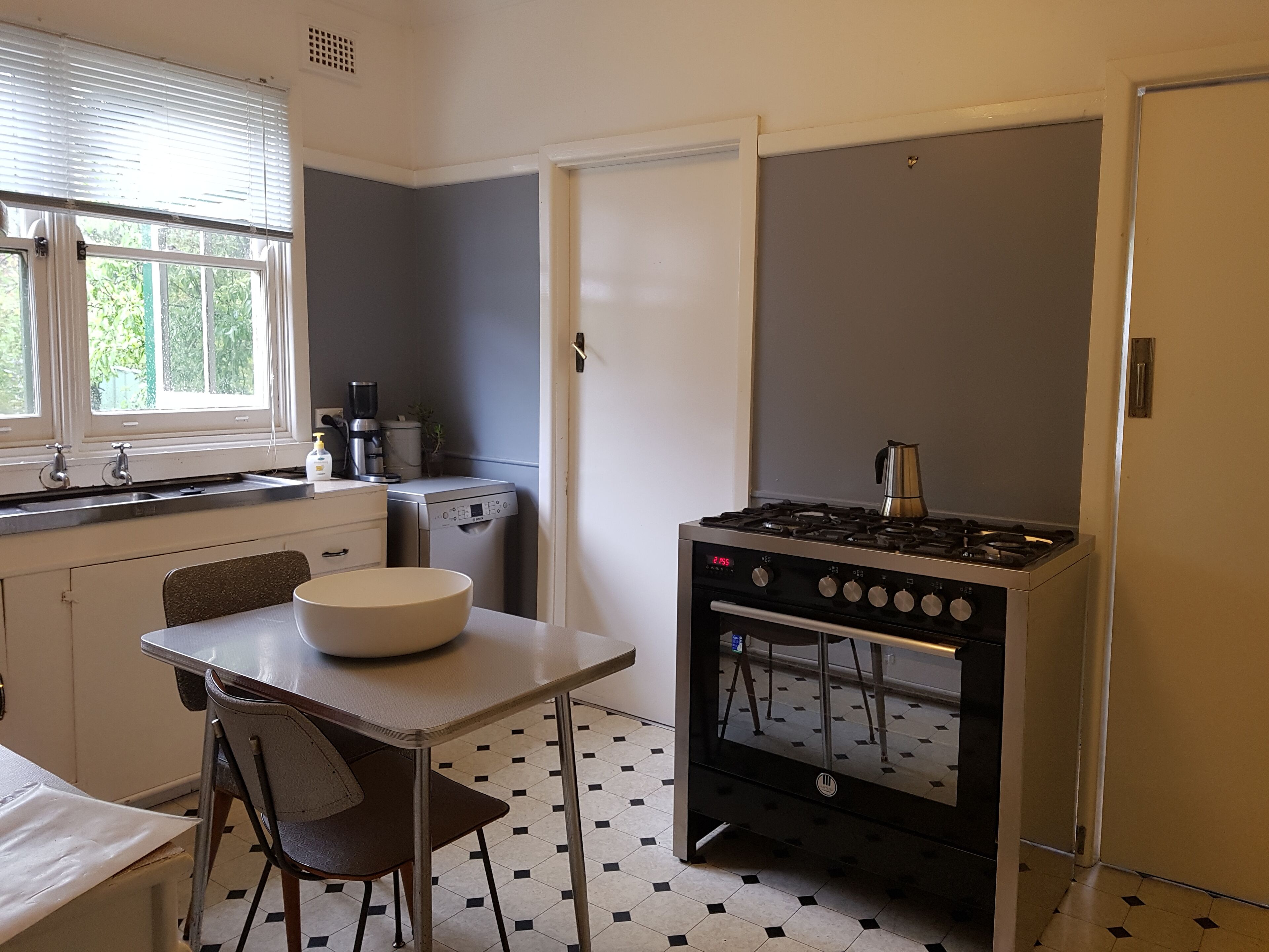 A compact kitchen with a gas stove, a coffee maker, and a dishwasher.