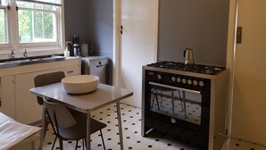 A compact kitchen with a gas stove, a coffee maker, and a dishwasher.