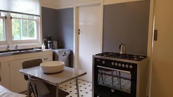 A compact kitchen with a gas stove, a coffee maker, and a dishwasher.