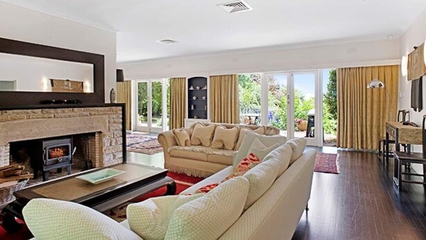 A living room with a fireplace, a sofa, and a dining area with a table and chairs.