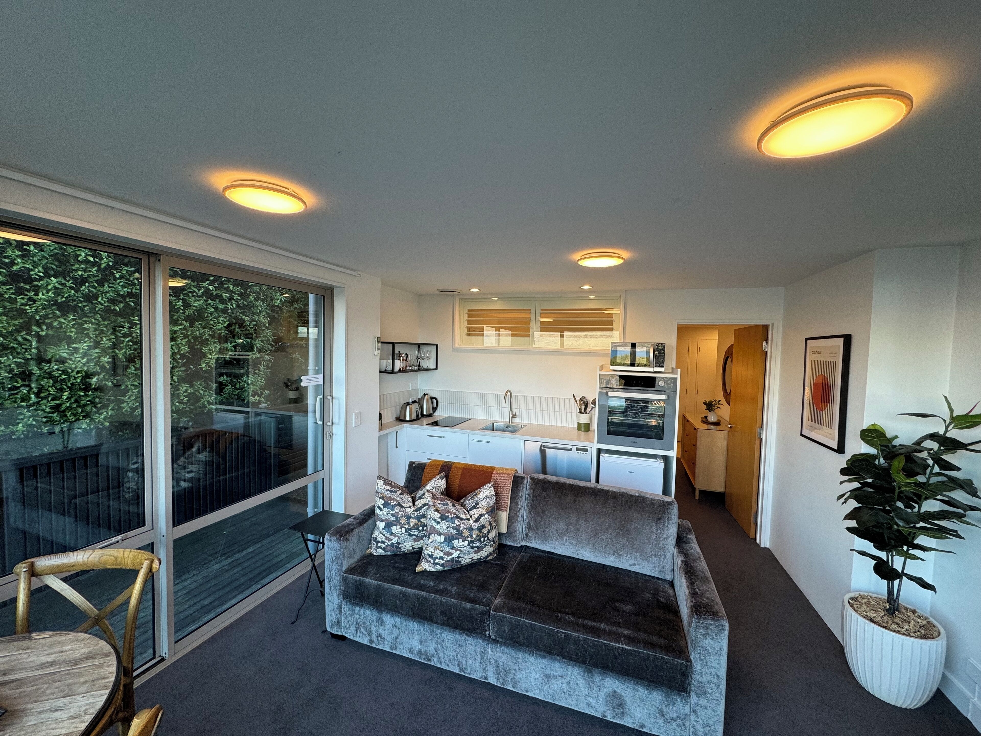 Un espacio habitable compacto con sofá, mesa de comedor y zona de cocina.