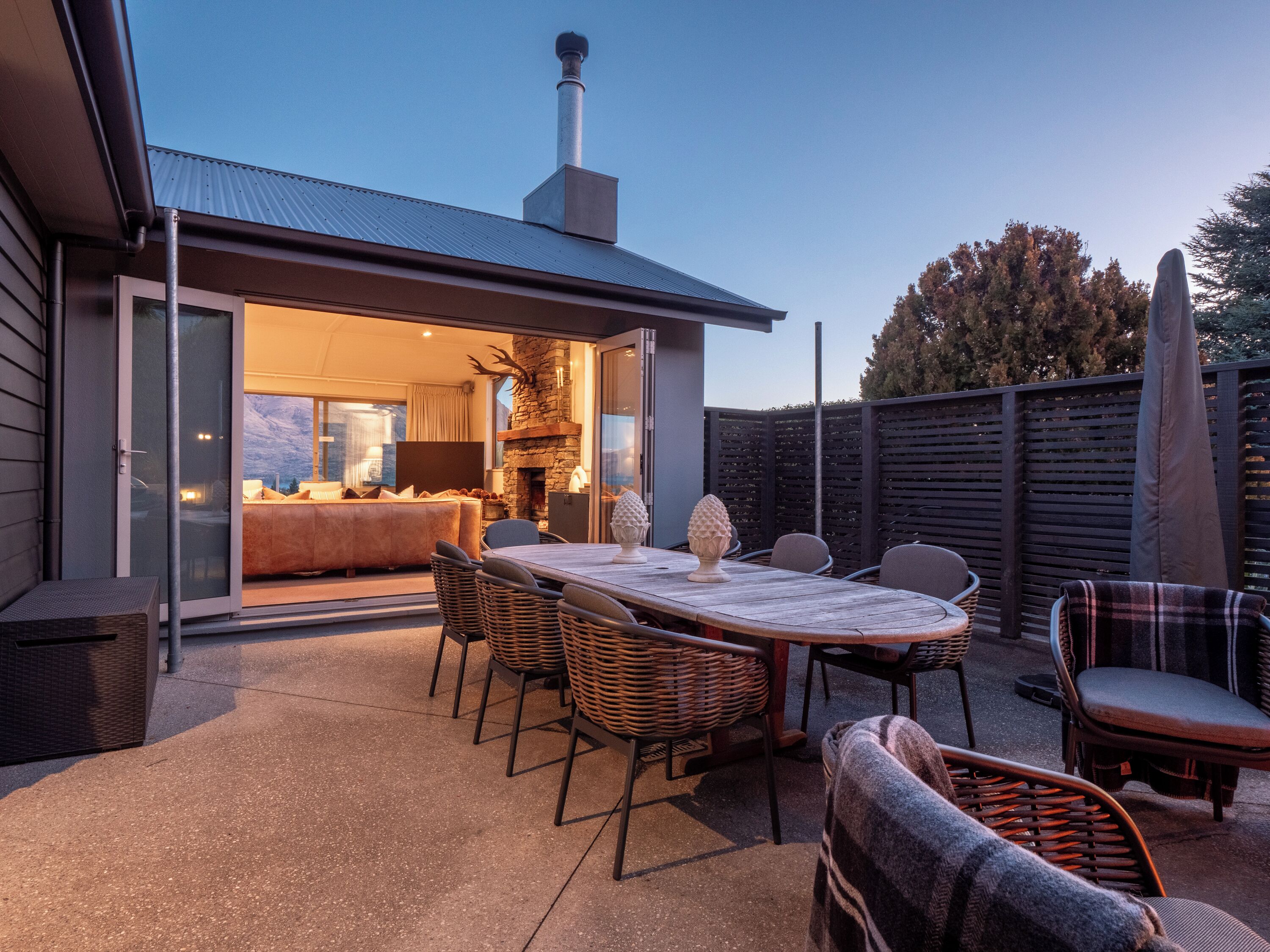 Un patio al aire libre con mesa, sillas y una chimenea.