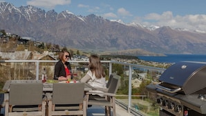 Two people seated at an outdoor table with a view of mountains and a body of water. - Lake View Villa | Great location | Amazing views (Queenstown)
