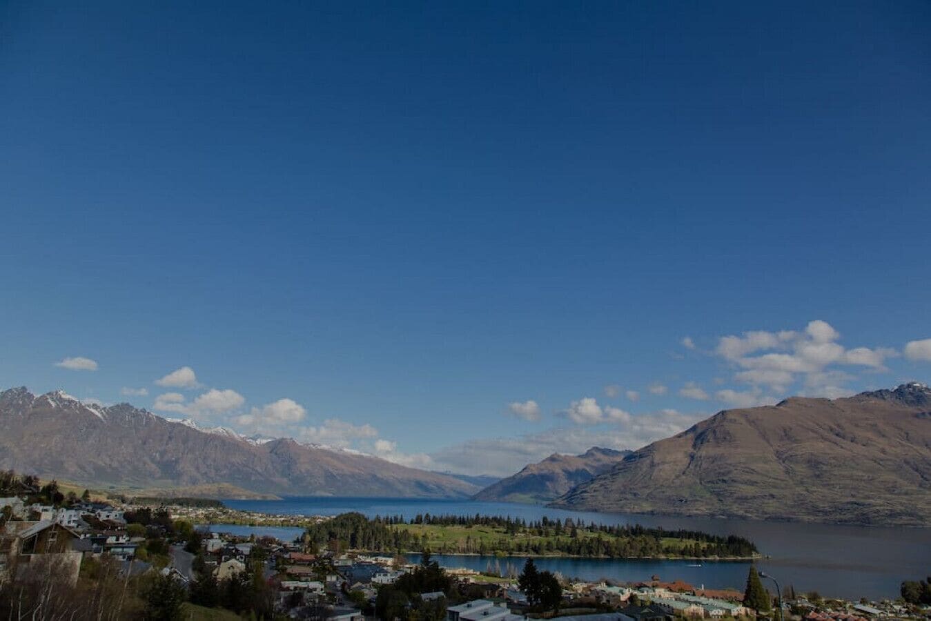 A lakeside town with mountains in the background.