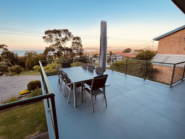 A terrace with a table and chairs, overlooking a residential area and a body of water. - Family Beach Home Dromana -Relax and take in the views of the bay (Dromana)
