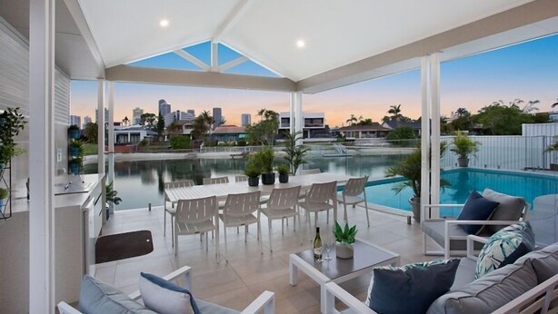 Un patio moderno al aire libre con piscina, zona de estar y vistas a la ciudad.