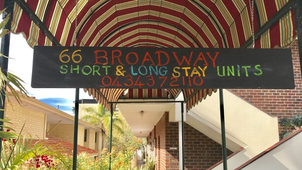 A sign for 66 Broadway Short & Long Stay Units with a contact number.