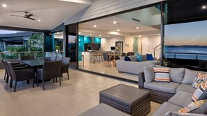 Un espacio moderno para el estar con una mesa de comedor, sofás y una cocina al fondo.