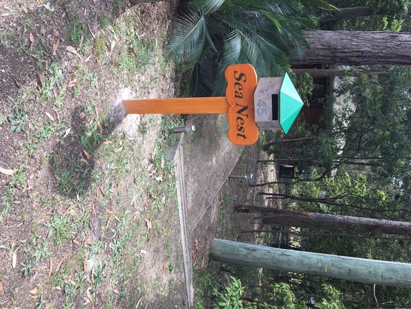 Un panneau en bois portant l’inscription « Sea Nest » et une flèche verte pointant vers la droite.